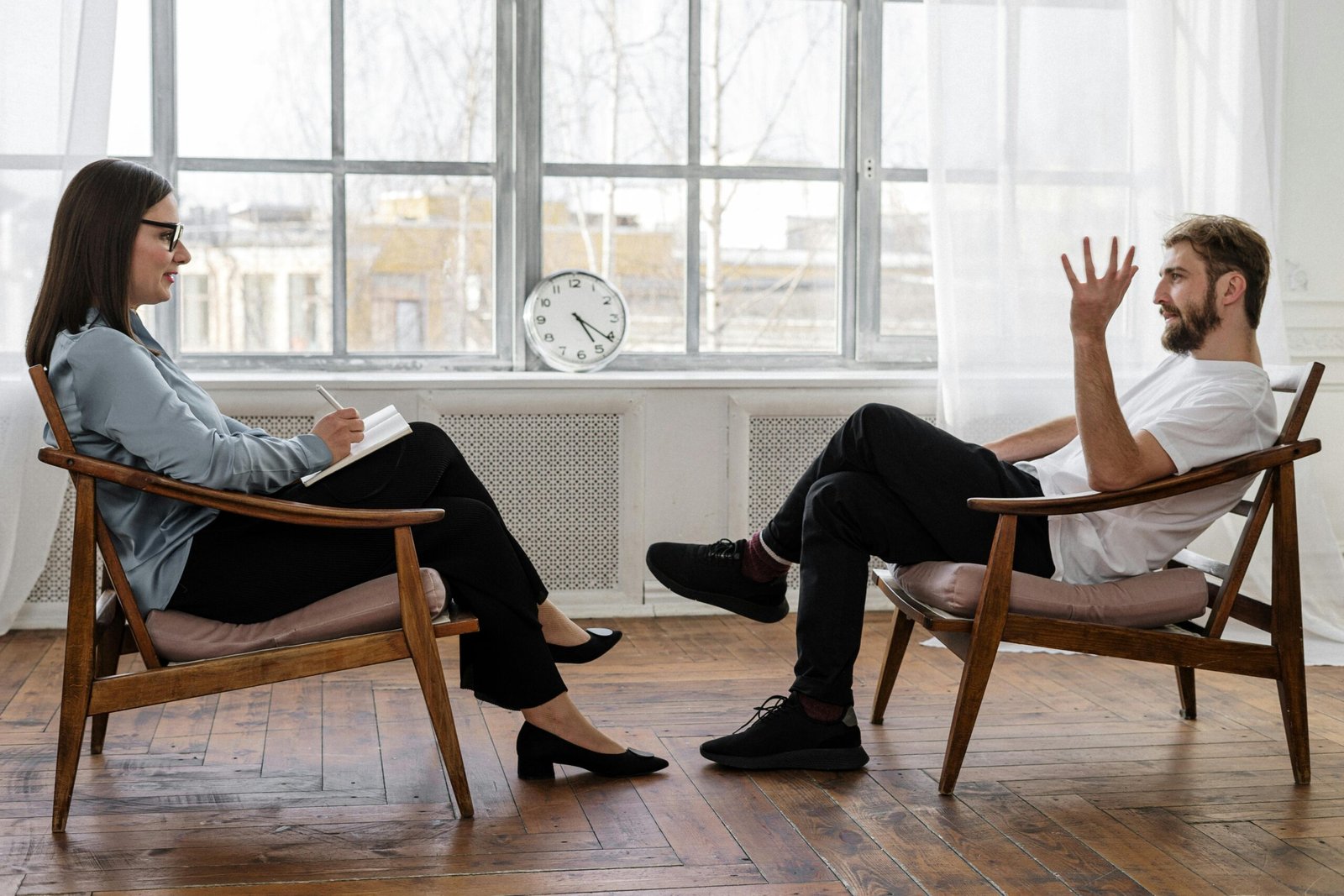 Home A therapist engaging in a counseling session with a male patient to support mental health.